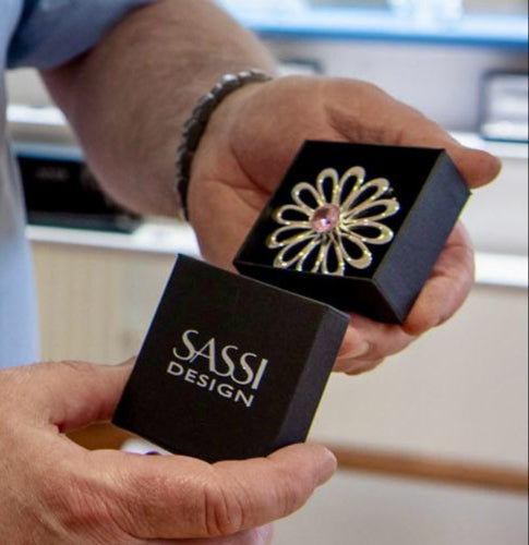  Sassi Designin upea, käsin valmistettu hopeinen rintakoru “Kesän Kukka” on täydellinen lahja kaikille, jotka arvostavat kauniita ja ainutlaatuisia koruja. Suuri kukkakuvio, jossa vaaleanpunainen kivi, pakattu kauniisti brändin omassa pakkauksessa. Tämä koru on ihanteellinen lahja tärkeisiin tilaisuuksiin ja rakkauden osoitukseksi.
